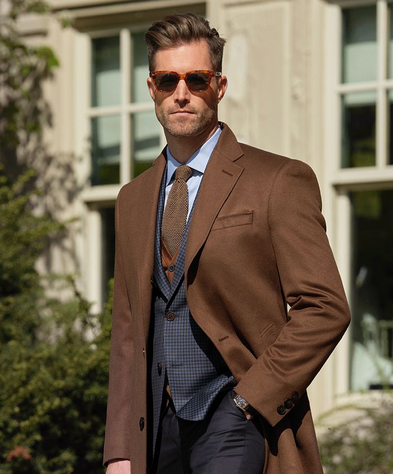 100% cashmere top coat (cloth 22970) over 100% wool blue and brown check 
sport coat (cloth 27586) paired with a navy 100% wool trouser (cloth 60211). All 
fabrics are woven in Italy