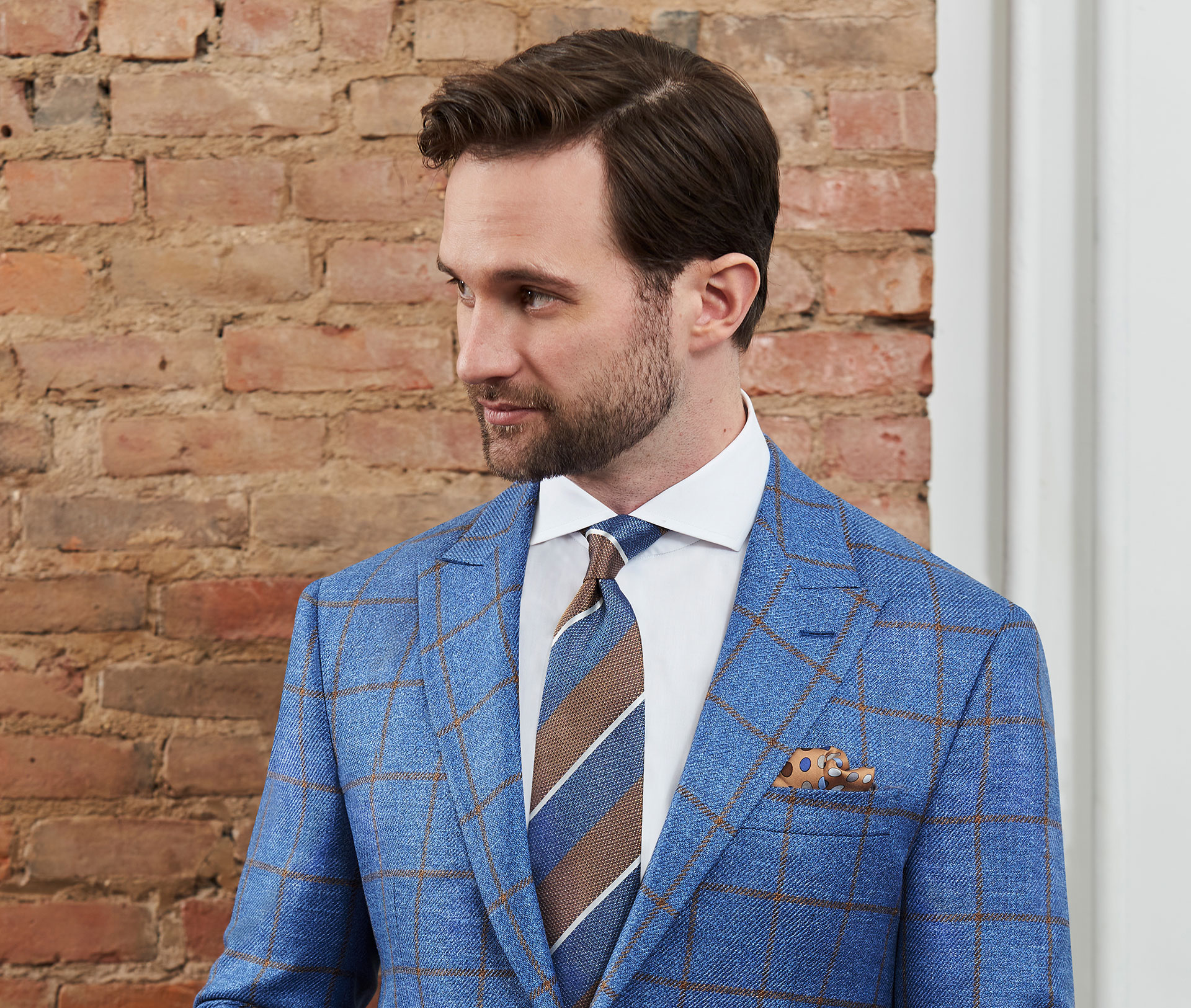 Man wearing blue wool, silk and linen sport coat with gold windowpane over check.