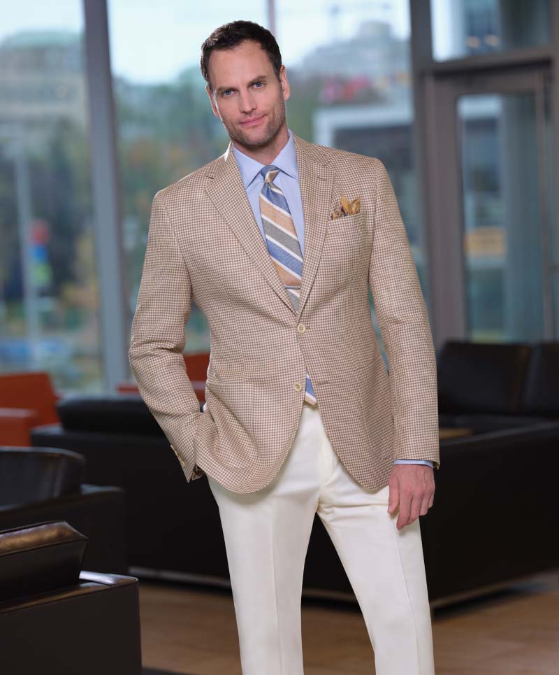 Man wearing a Tan and white houndstooth sport coat in wool, silk, and linen summer blend fabric
from Italian fabric mill, Drago (cloth # 27959) paired with 100% wool cream trou-
sers. (Cloth # 9645)