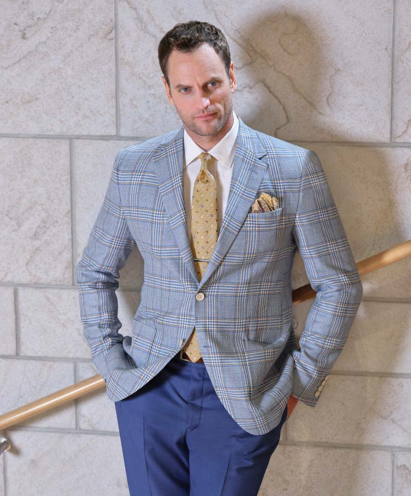 Man wearing Light blue and tan plaid sport coat ( cloth #28005) with blue Super 130’s trousers
(cloth #60233). Fabric woven in Italy